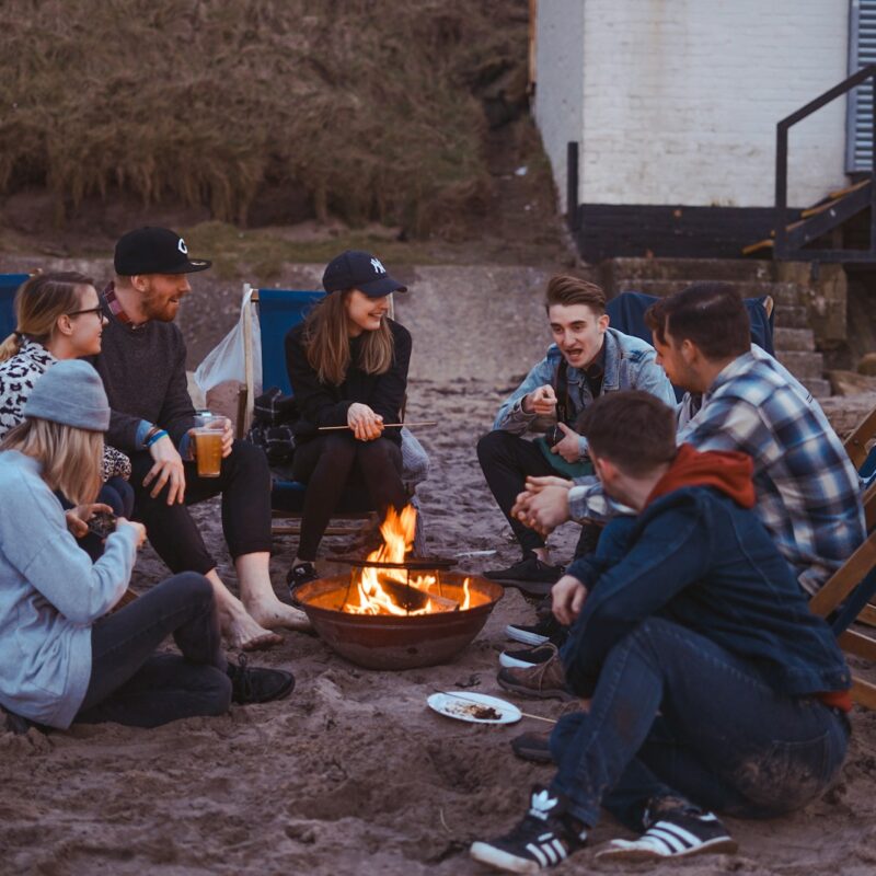 group of people sitting on front firepit